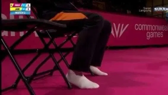 马来西亚教练叶诚万穿着袜子坐在教练席指导。（互联网）