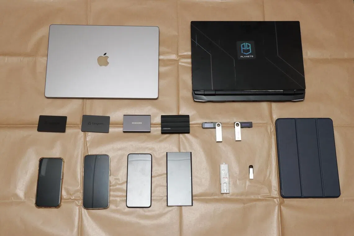 2024年9月9日，警方在多个地点同时进行的突击搜查中，查获了电子设备和现金，并逮捕涉案男子。（新加坡警察部队提供）