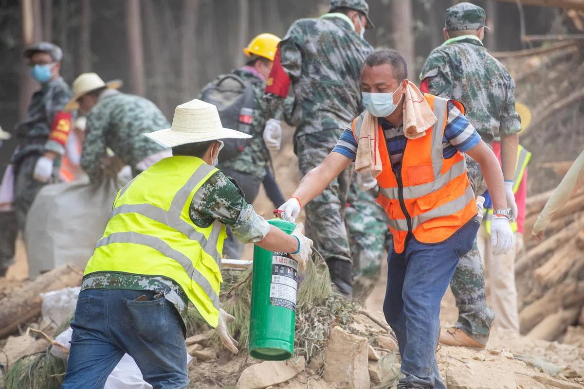 8月26日，消防、武警等救援力量和志愿者在重庆北碚区歇马街道运送物资。（新华社） 