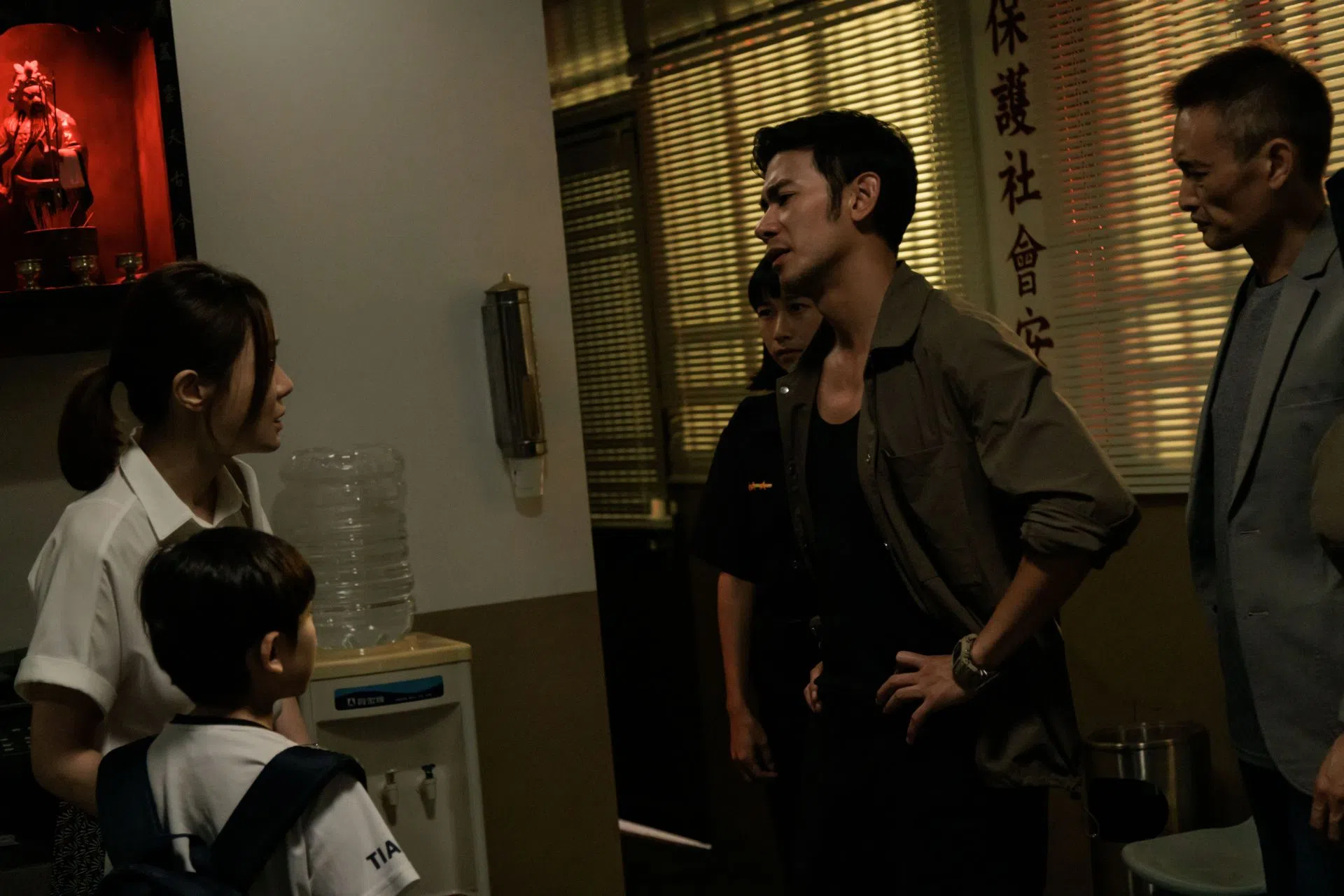 李子健（右二，亮哲饰）在同事张力失踪后，逼着其妻子张亚男还钱。