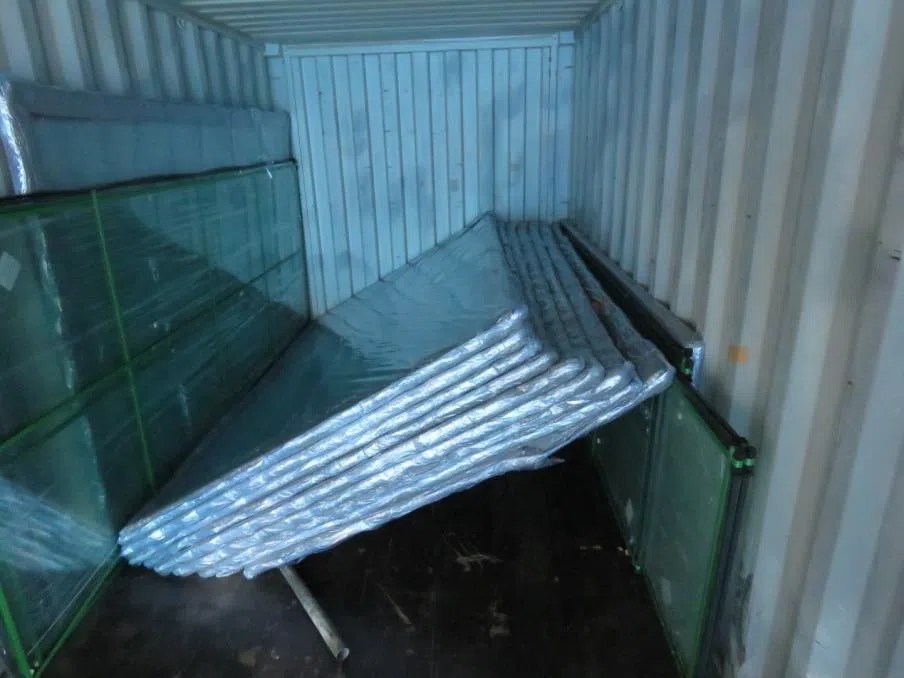 两名工人把玻璃门搬出集装箱时，其中九片突然倒下压在他们身上，造成一死一伤。（人力部提供）