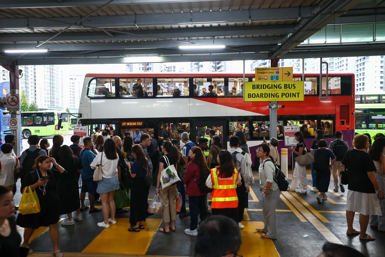 傍晚尖峰时段，许多乘客改乘榜鹅轻轨站外的接驳巴士。（陈渊庄摄）