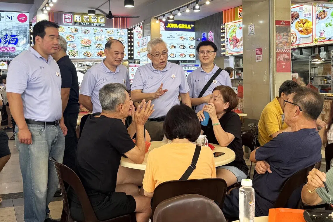 人民力量党秘书长吴明盛（右二）星期天上午与党员一起走访淡滨尼集选区。（尹云芳摄）
