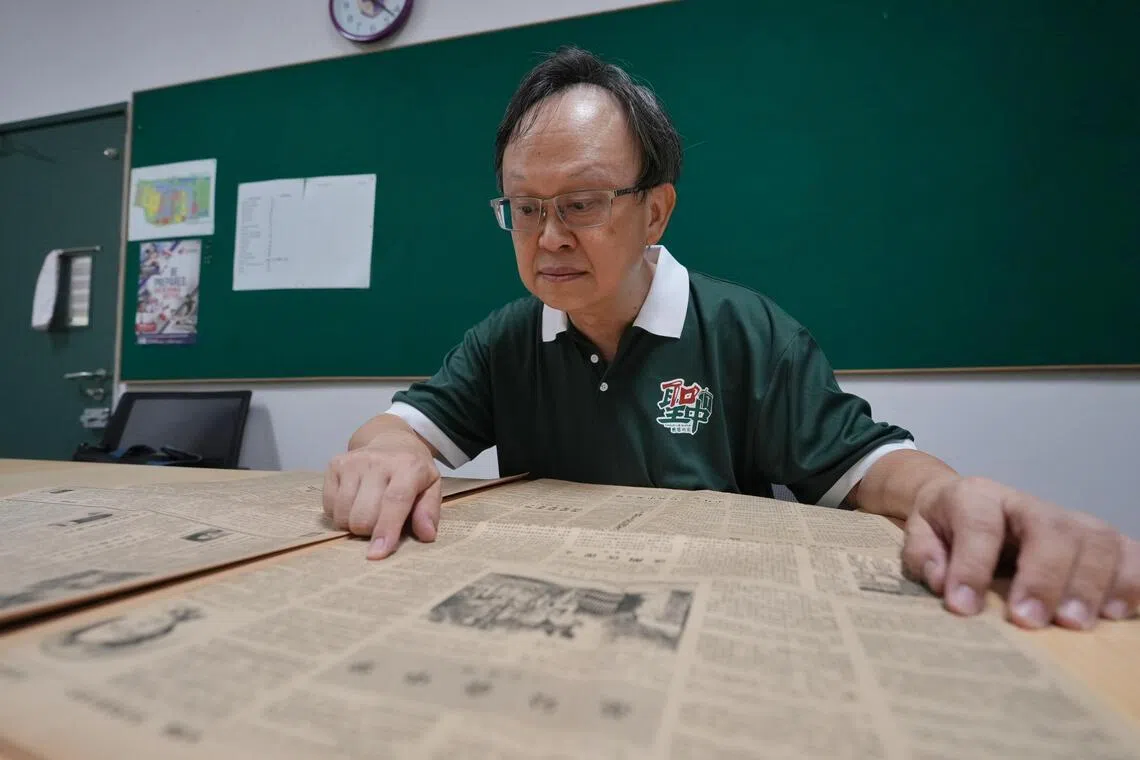 也是圣中校友的数学教师傅星吉在整理学校文物时，发现《南洋商报》1978年一篇有关圣中的报道，提及学校要建小学的计划。（谢智扬摄）