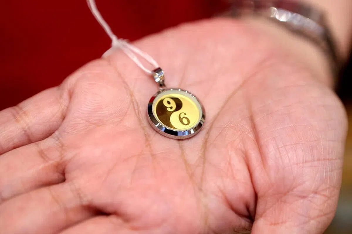 黄金金庄珠宝行独家设计的金牌“96”，“9”代表事业，“6”代表财运；“6”象征阴，“9”象征阳，许多客户都会买来赠送好友。（龙国雄摄）