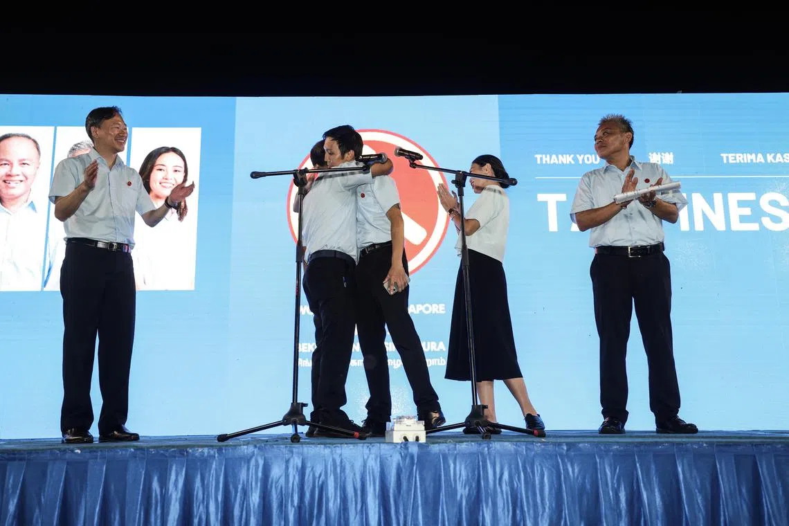 工人党参选淡滨尼集选区的王锐斌（左起）、莫哈默费沙、唐光伟、蒋佩姗和陈钦德感谢选民支持。唐光伟感谢领军的莫哈默费沙过去15年来在阿裕尼集选区作出的贡献，并拥抱他。（关俊威摄）