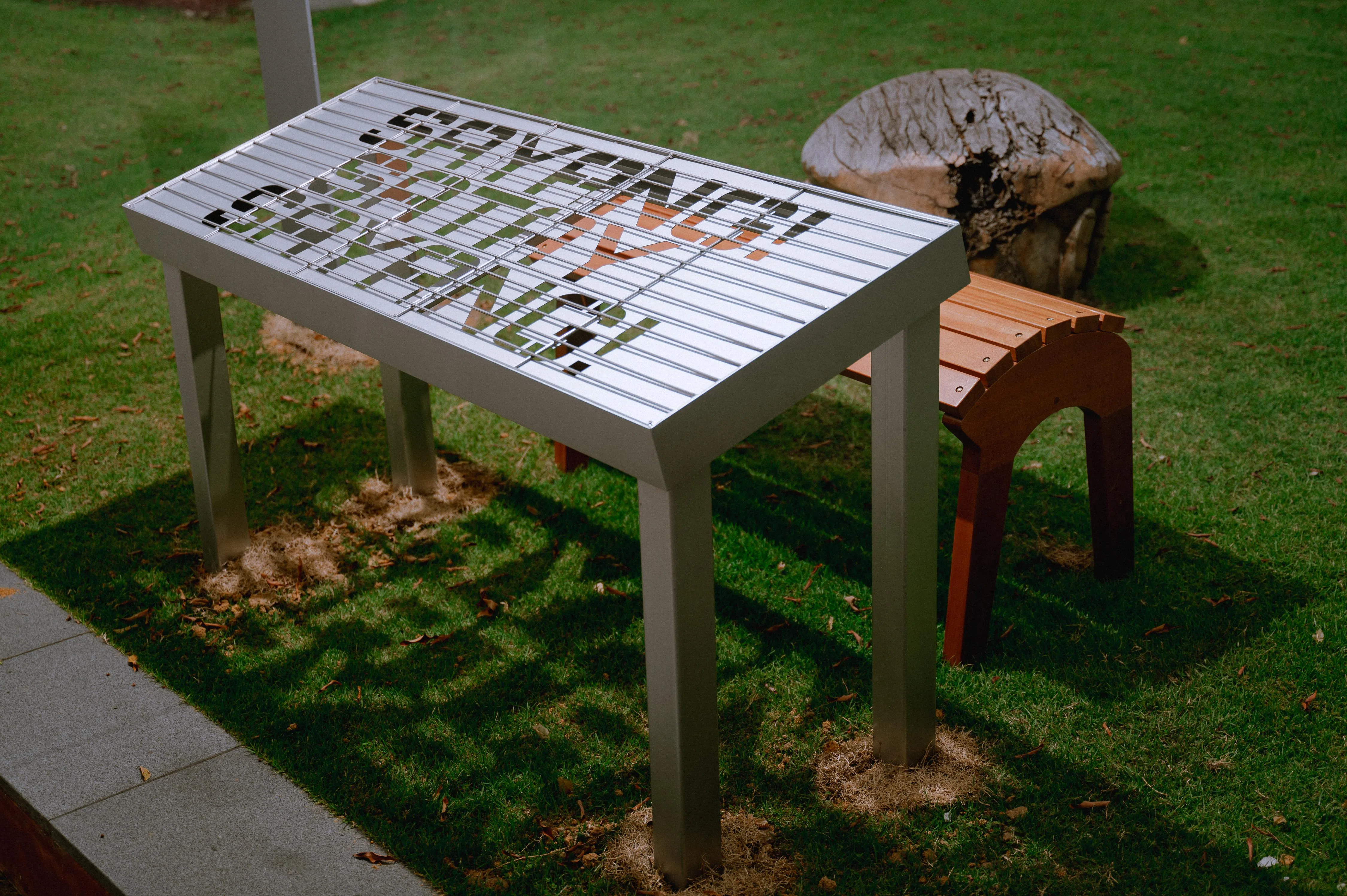 阳光将《亲爱的！亲爱的沙爹！》字体投射到草地上。（艺术之家提供）