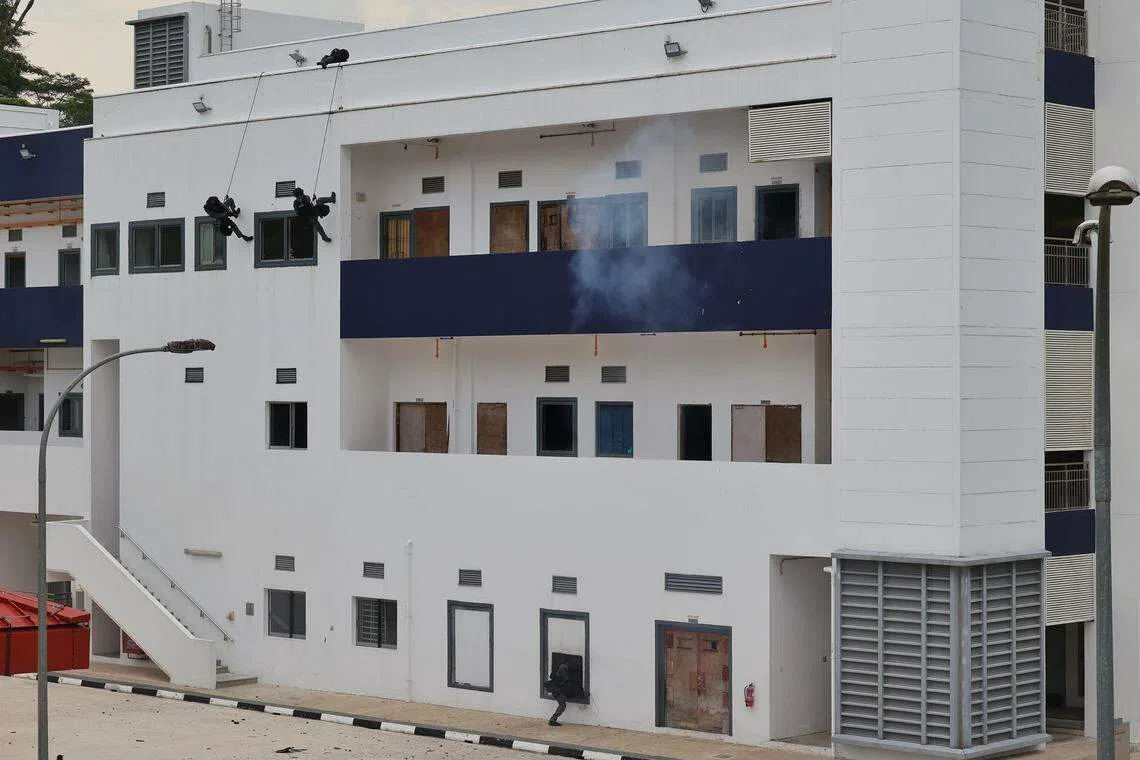 特工与拯救单位队员悬绳而降，安装炸弹破坏门窗，攻其不备将恐怖分子逮捕归案。（唐家鸿摄）