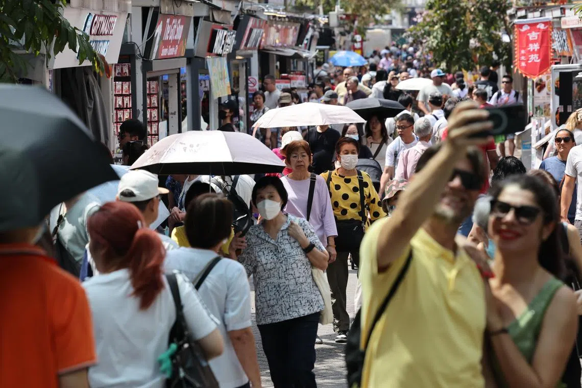 同样是星期一（5月12日）卫塞节公假当天下午，牛车水却是烈日当空，许多来新加坡游玩的旅客和出门逛街的本地人都打起遮阳伞。（梁麒麟摄）