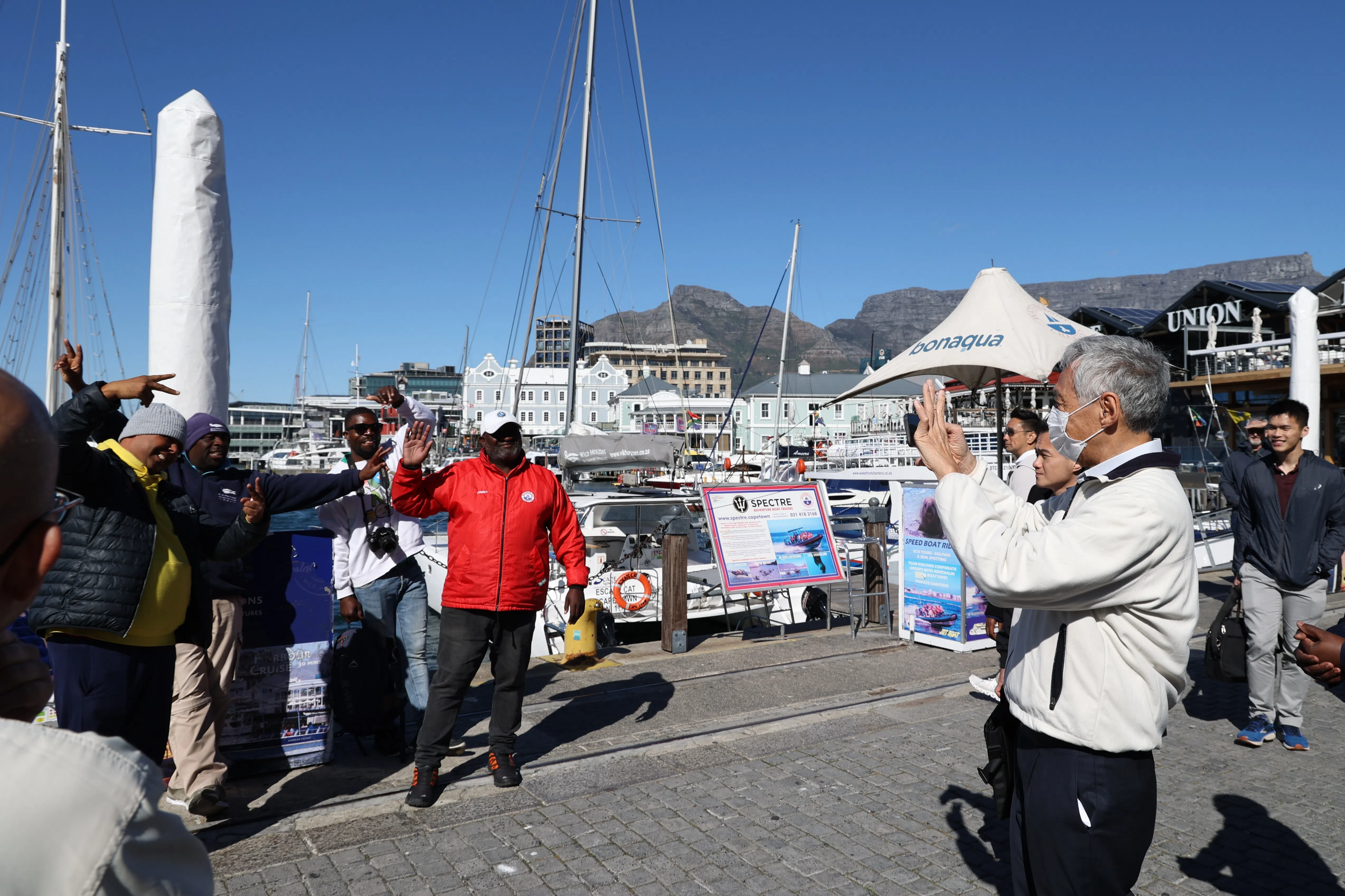 李总理举起手机，捕捉码头上人们灿烂的笑容。（何家俊摄）