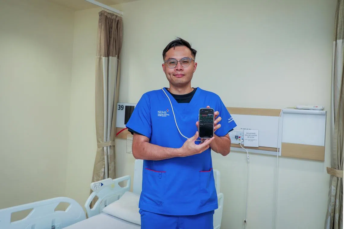 在黄廷方综合医院，助理临床护理导师哈菲兹用手机就可看到病人的实时体征指数。这些信息是通过无线穿戴检测配备收集，省却人手操作。（张恺恩摄）
