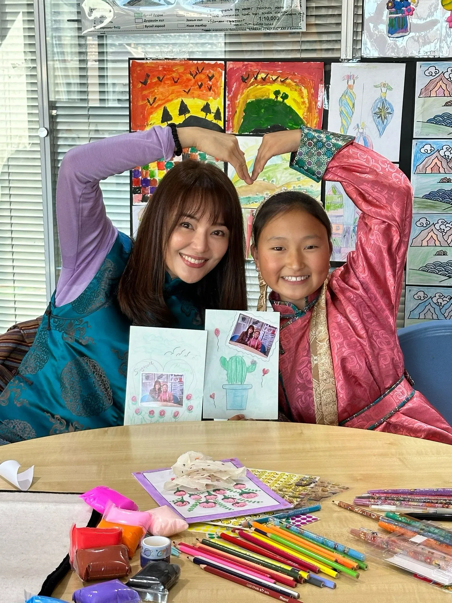 洪乙心（左）与助养六年的孩子在乌兰巴托见面，她身穿的深绿色服饰为女孩妈妈所缝制。（洪乙心提供）
