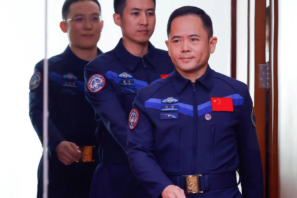 中国航天员张陆（右起）、武飞、张洪章星期四（10月30日）在酒泉卫星发射中心举行的记者会上亮相。（路透社）