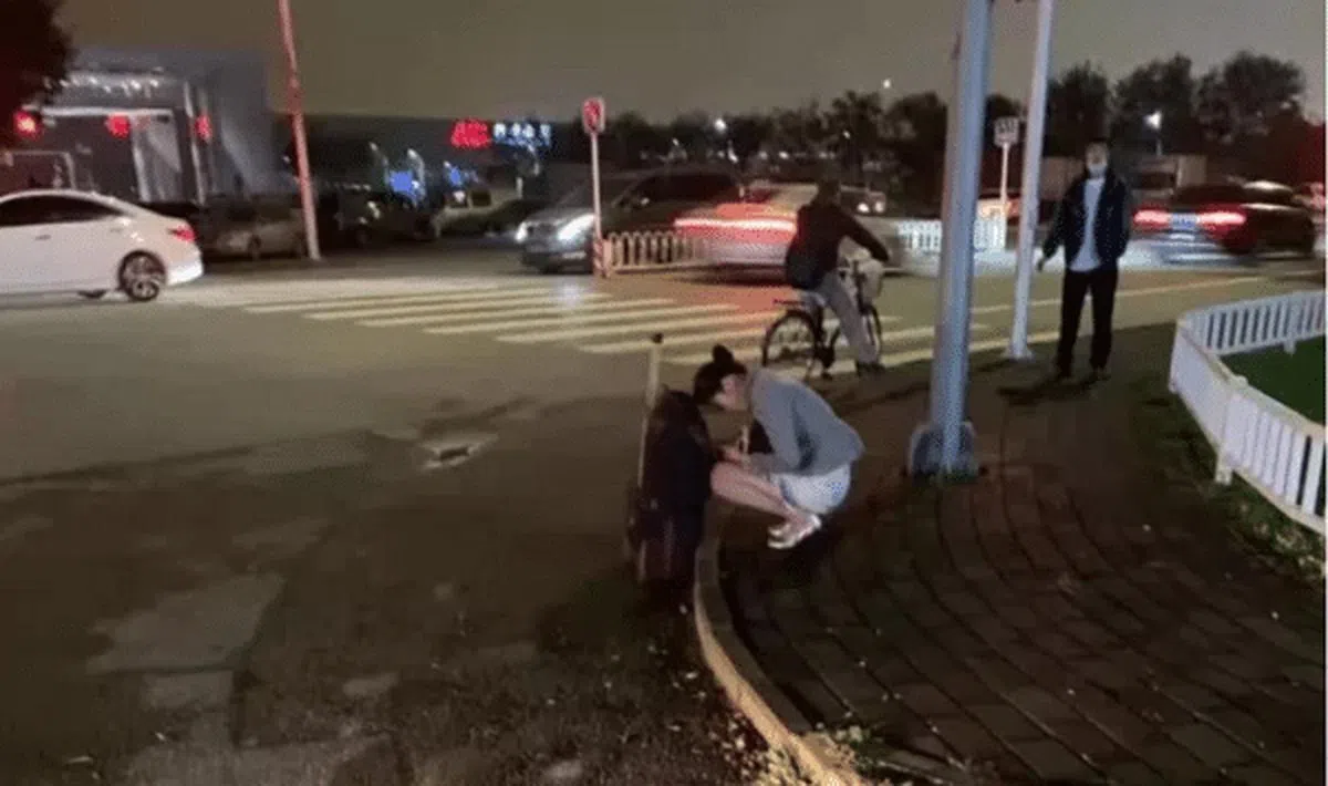 海航一名空姐着夏服蹲在路边等车冻得瑟瑟发抖。（互联网）