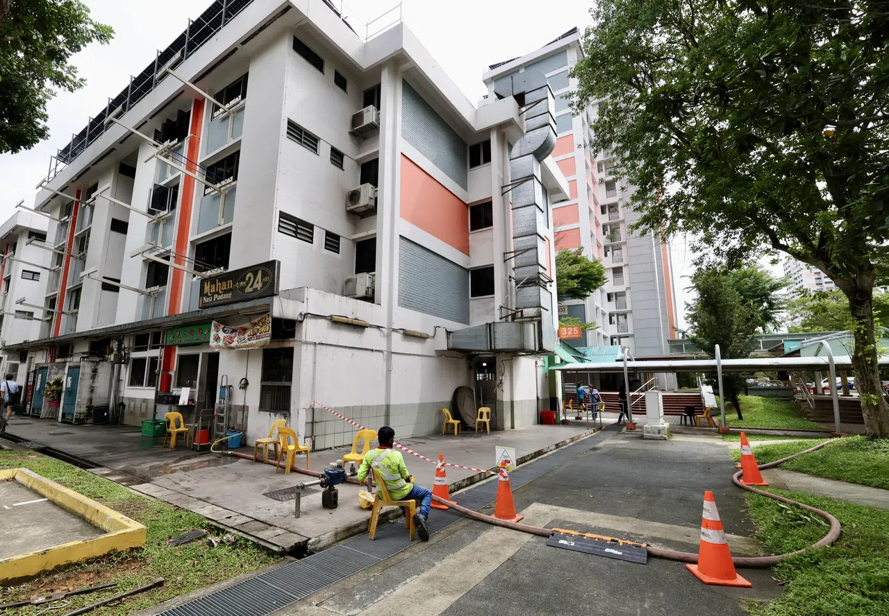 第325座组屋底层的商家受影响，当局事后封锁附近区域进行抢修。（邬福梁摄）