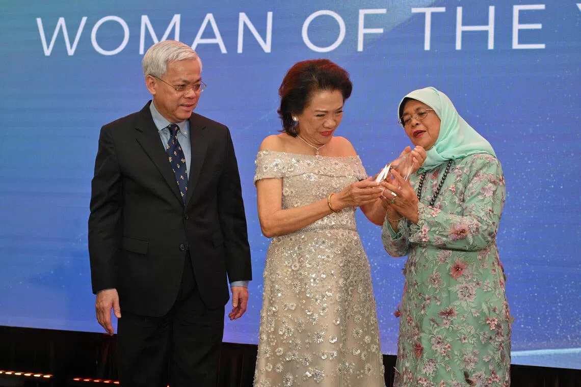 新社科大名誉校长、前总统哈莉玛（右）和新报业媒体总裁陈英杰（左）为曾秀娘（中）颁发《她的世界》2025年度杰出女性奖奖杯。哈莉玛也是2003年度杰出女性奖得主。（唐家鸿摄）