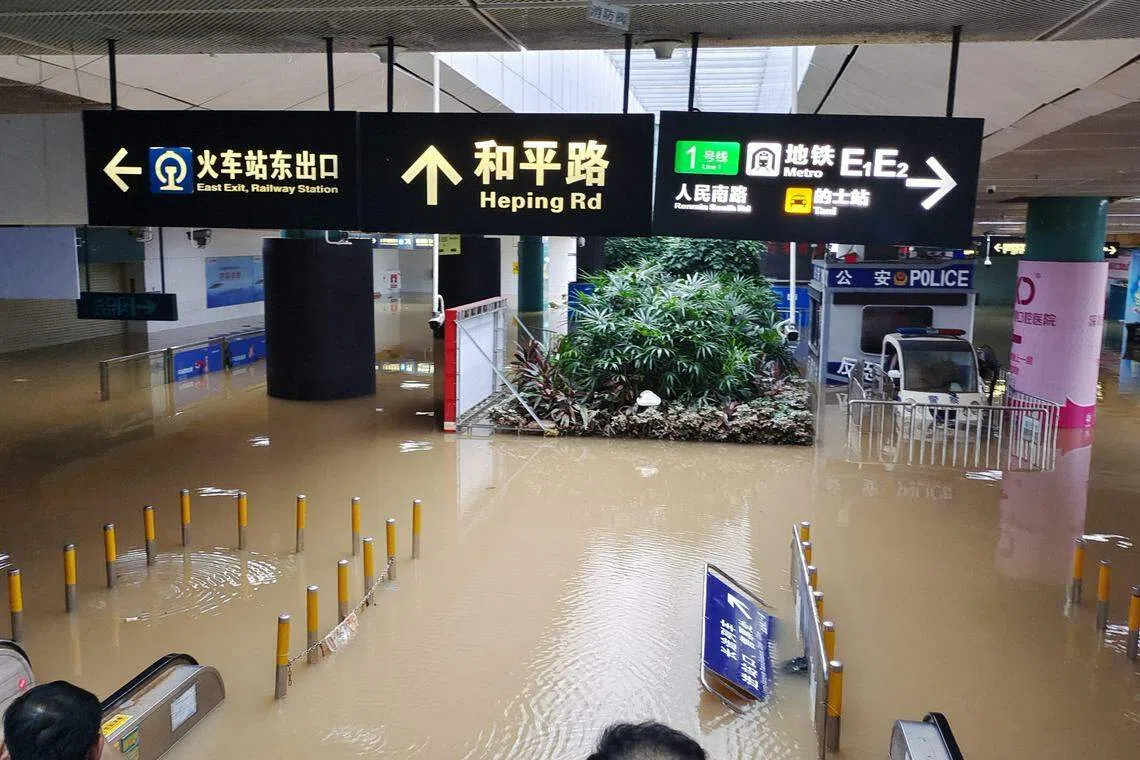 受暴雨影响，深圳火车站的负一楼进出站口被水淹，乘客无法正常进出站，一度有约百人被滞留在站内。（中新社）