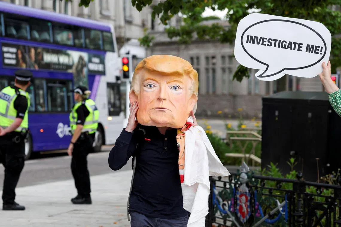 一名示威者星期六（7月26日）戴着美国总统特朗普的纸糊头像进行示威，抗议特朗普的来访。（路透社）