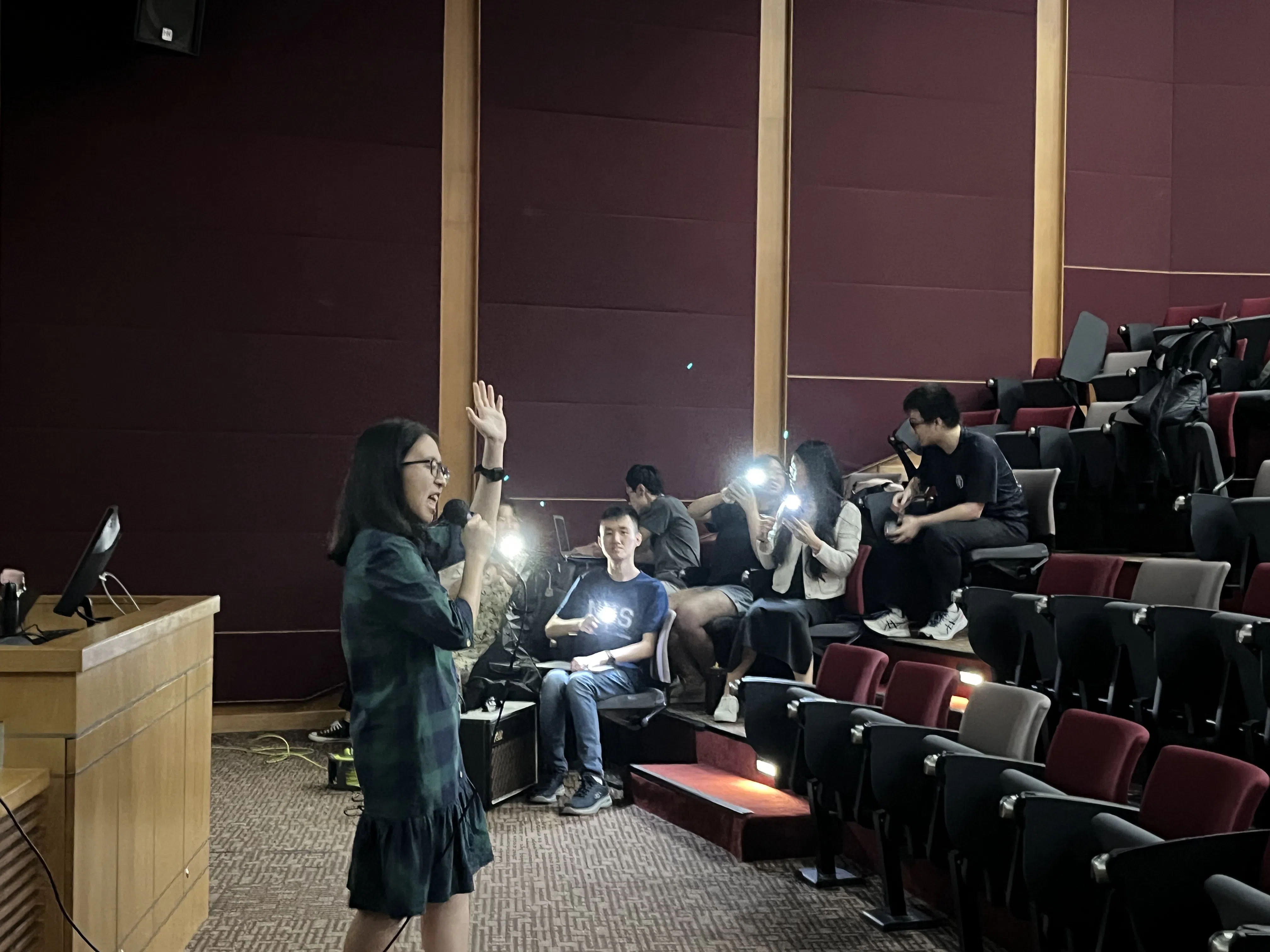 大四学生李欣融献唱周杰伦的《发如雪》，大家打开了手机的手电筒，随着音乐摇摆，如同迷你演唱会。（国大中文系提供）