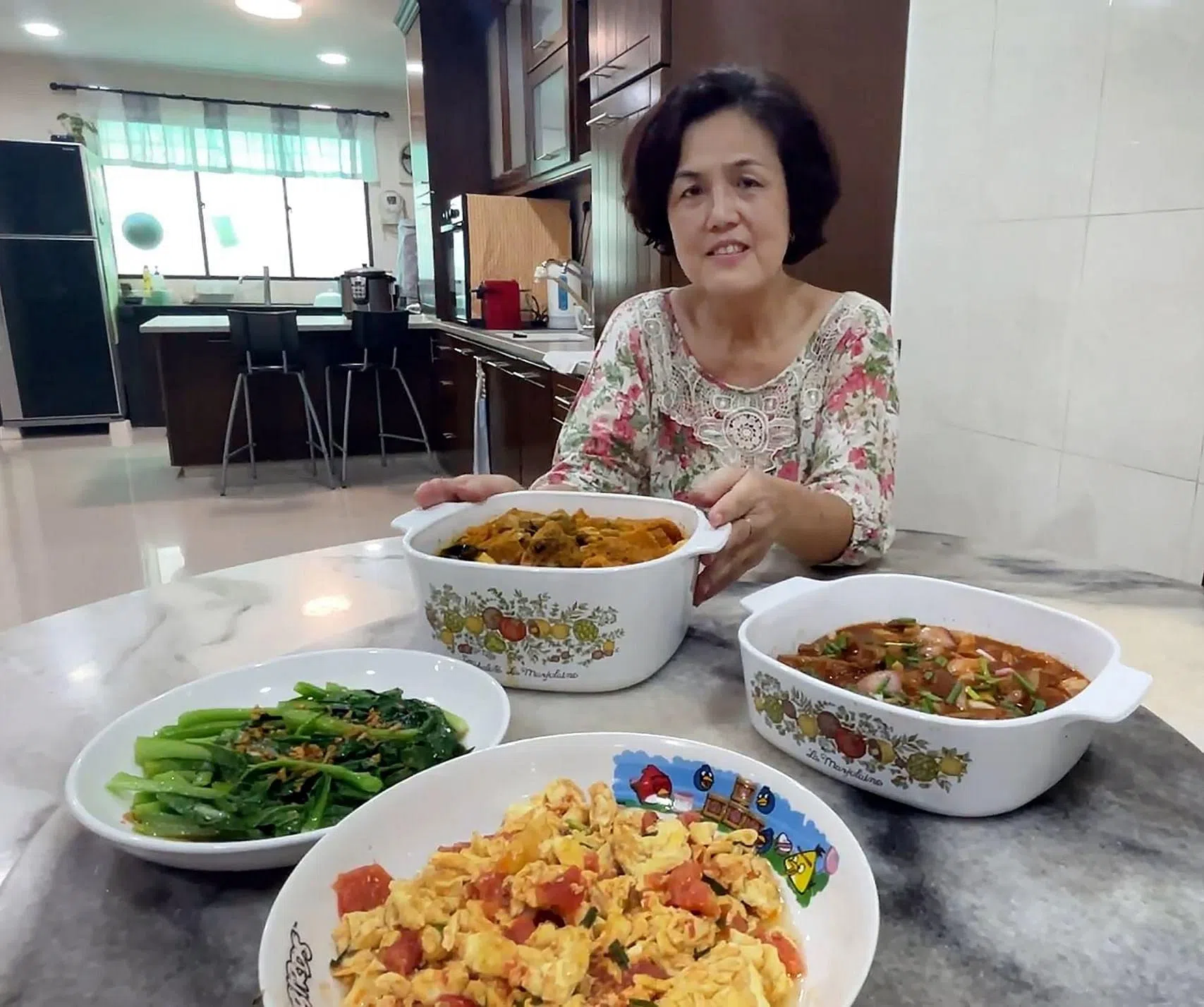 陈莉莉准备的午餐包括咖喱鸡加猪皮、酸甜排骨、番茄炒蛋和油菜。这四道菜肴的食材共计62令吉（约20新元）。（萧郡瑜摄）