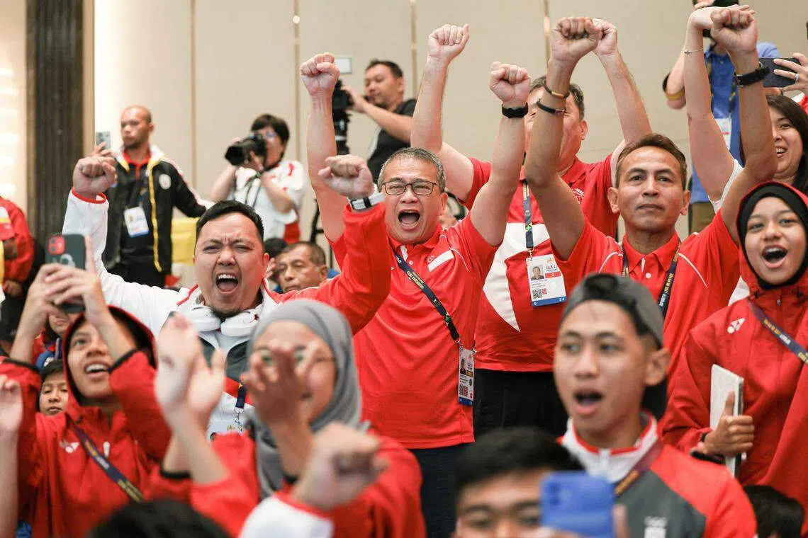 我国马来武术女队在团体艺术赛战胜文莱夺金。在分数公布的那一刻，包括文化、社区及青年部长兼律政部第二部长唐振辉在内的我国支持者，都兴奋得高举双手欢呼。（李冠卫摄）
