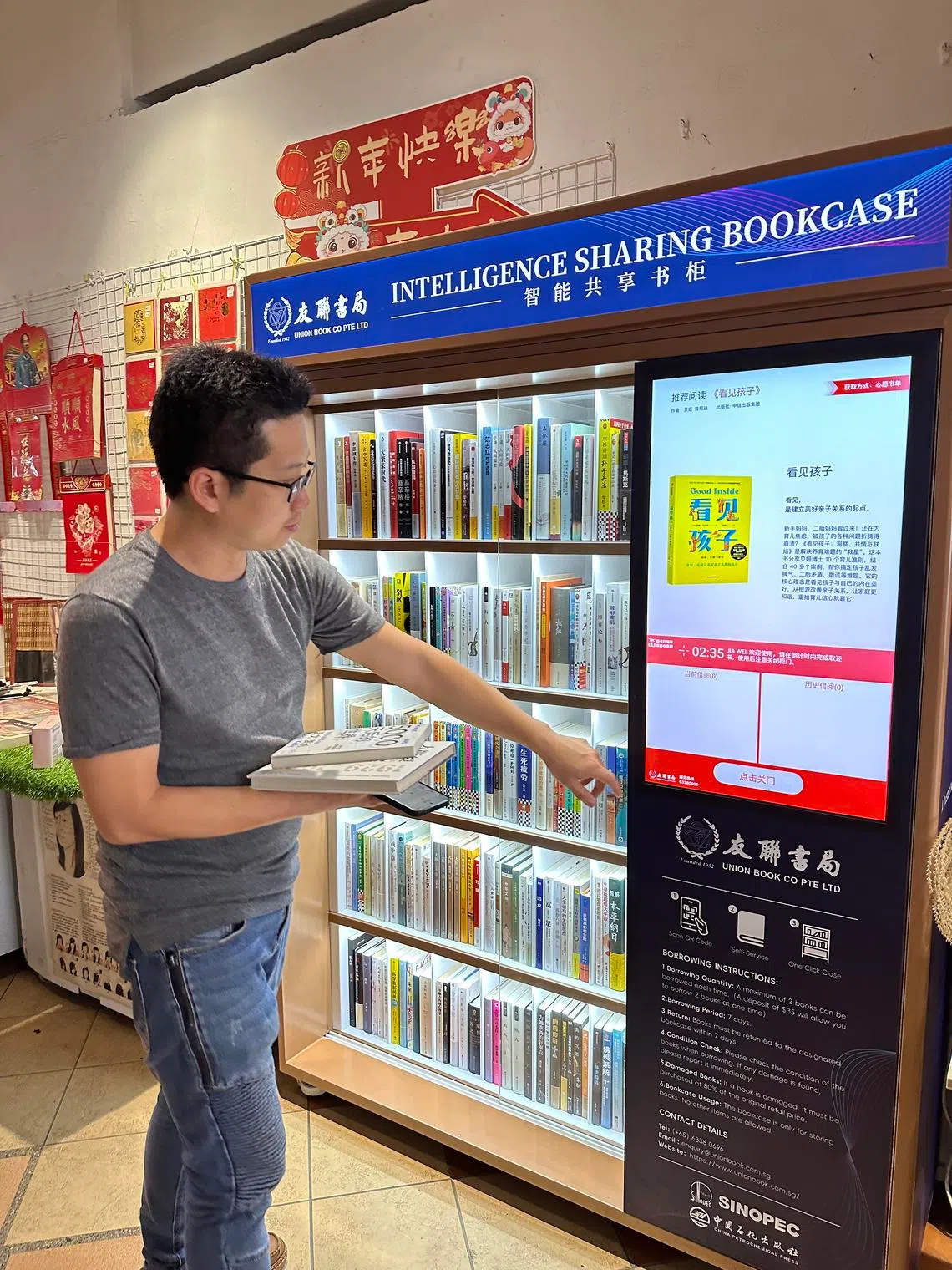 友联引进智能共享书柜，公众扫码注册后即可免费借阅畅销华文书籍。（齐鲁摄）