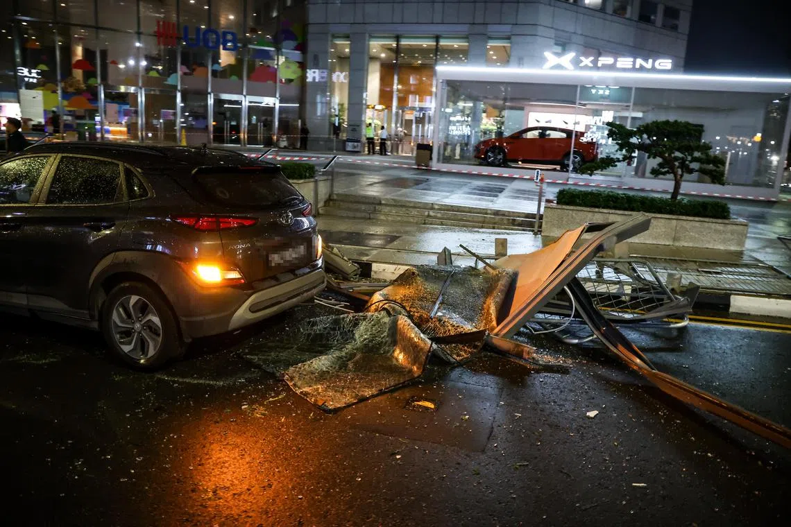 路上可见大片落下的玻璃和金属结构，至少四辆路过的车子受损。（关俊威摄）