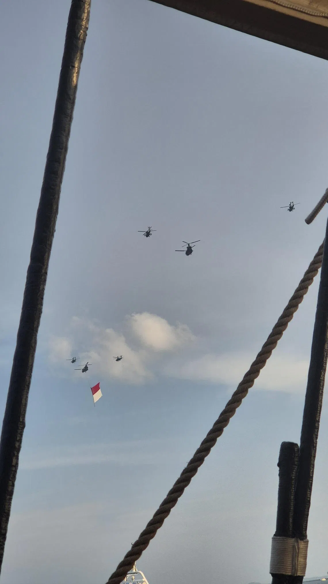在甲板上看挂着国旗的空军编队飞过天际。（陈爱薇摄）