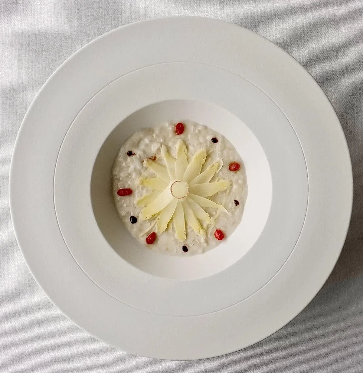 白芦笋粥以白芦笋薄片、枸杞子及几滴黑醋作点缀，摆盘淡雅。