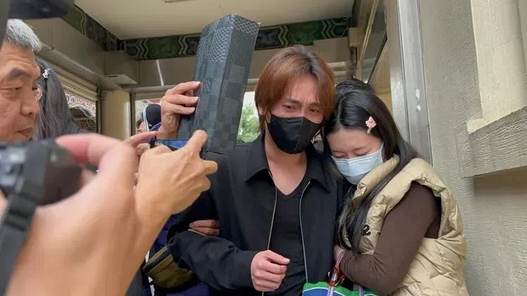 曹西平的干儿子Jeremy（戴口罩者）与女友前往验尸房时神情哀伤。（互联网）