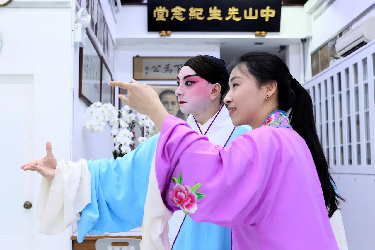 王洁与社友杨天熙（右）在天韵京剧社排戏。（龙国雄摄）