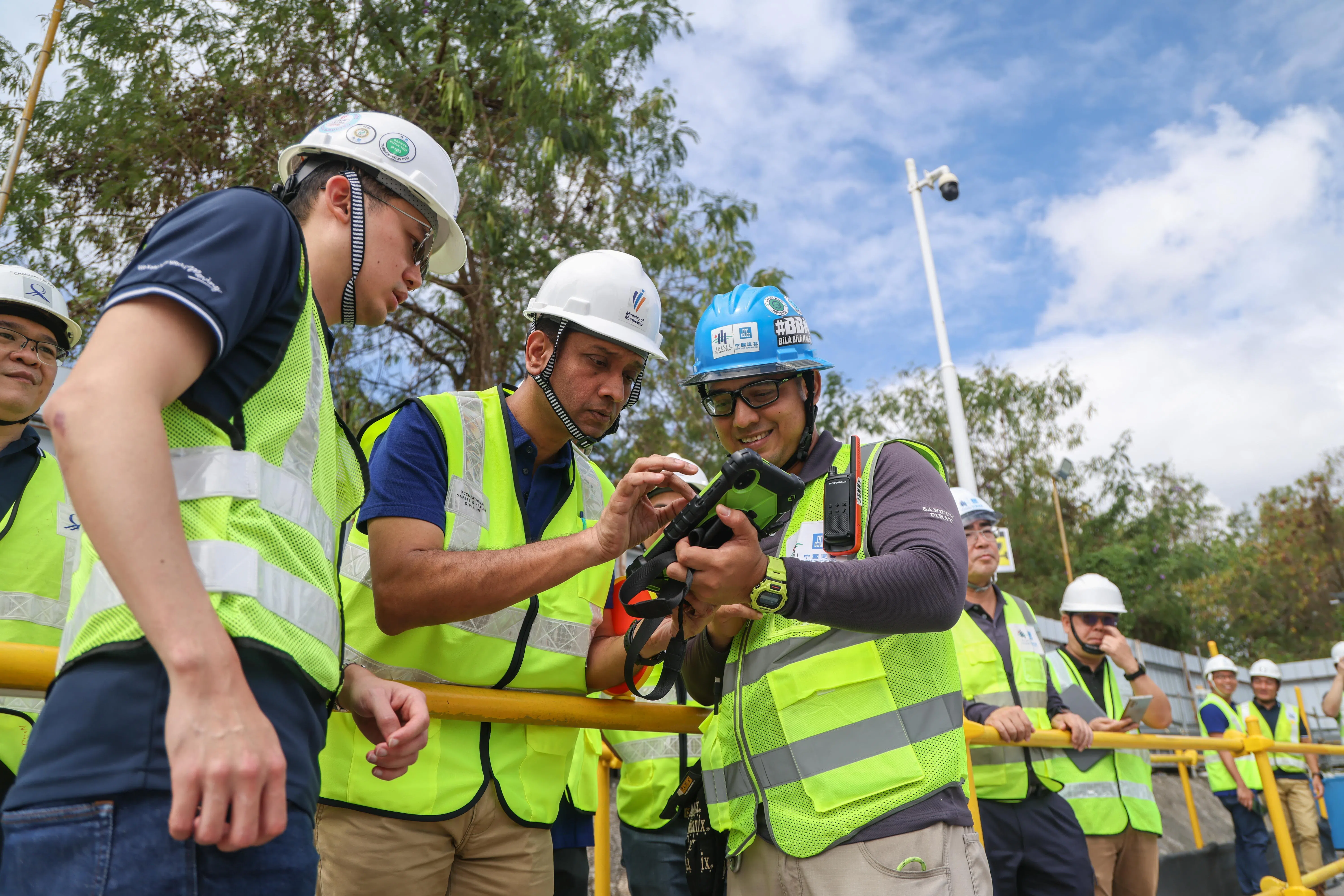 大成建设和中国建筑集团组成联营公司的工作场所安全与卫生协调员努鲁再尼（左三），向人力部政务部长迪内希（左二）解释安全工地视频分析系统如何运作。左一为陆交局项目经理刘忠廉。（白艳琳摄）