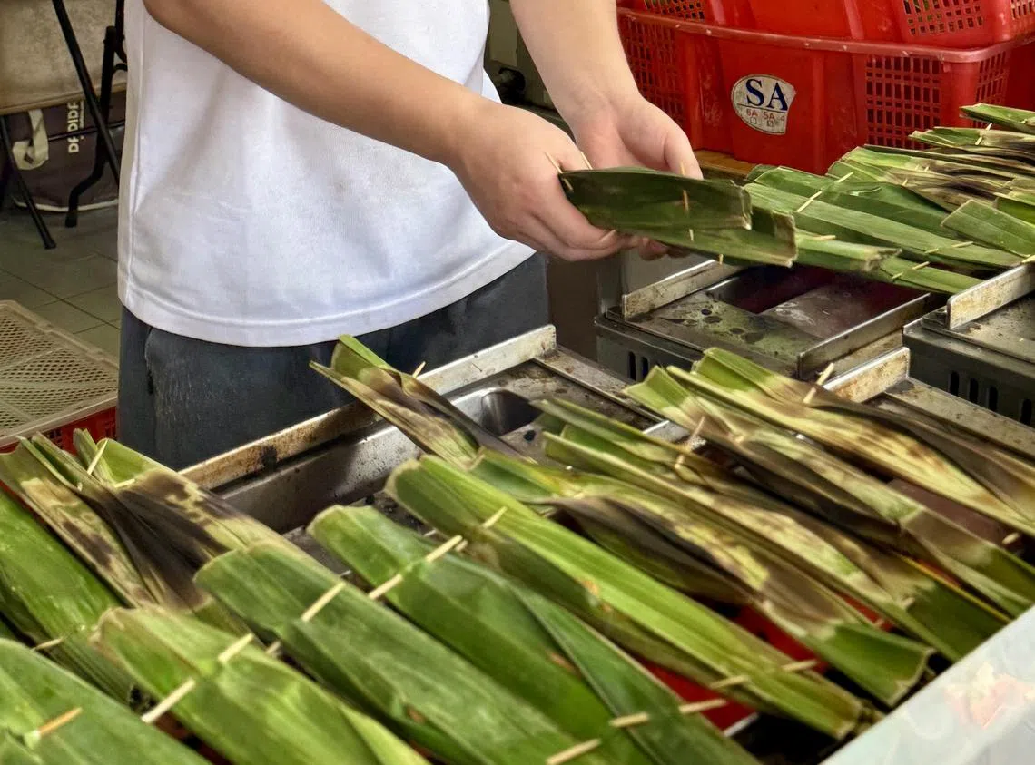 员工在店门前现烤乌打。（叶晓虹摄）