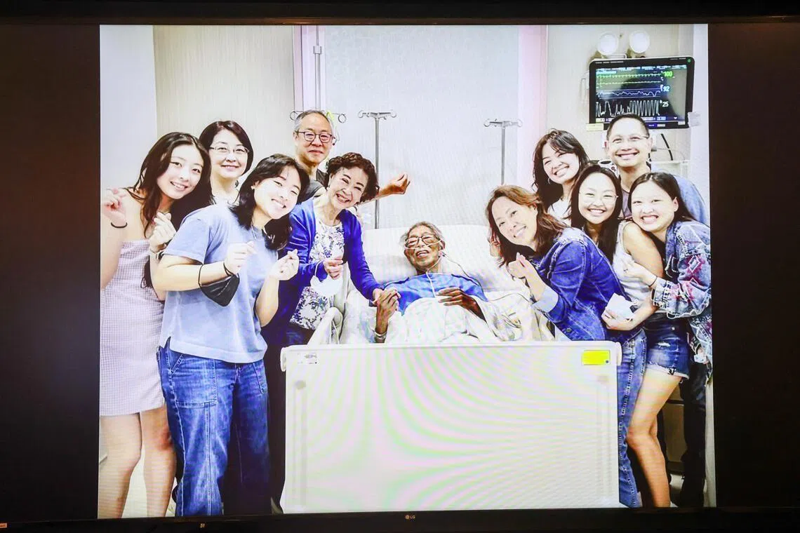 灵堂上播放的照片，郭振羽（中）祖孙11人三代同堂，在最后时光留下温馨合影。（陈斌勤摄）