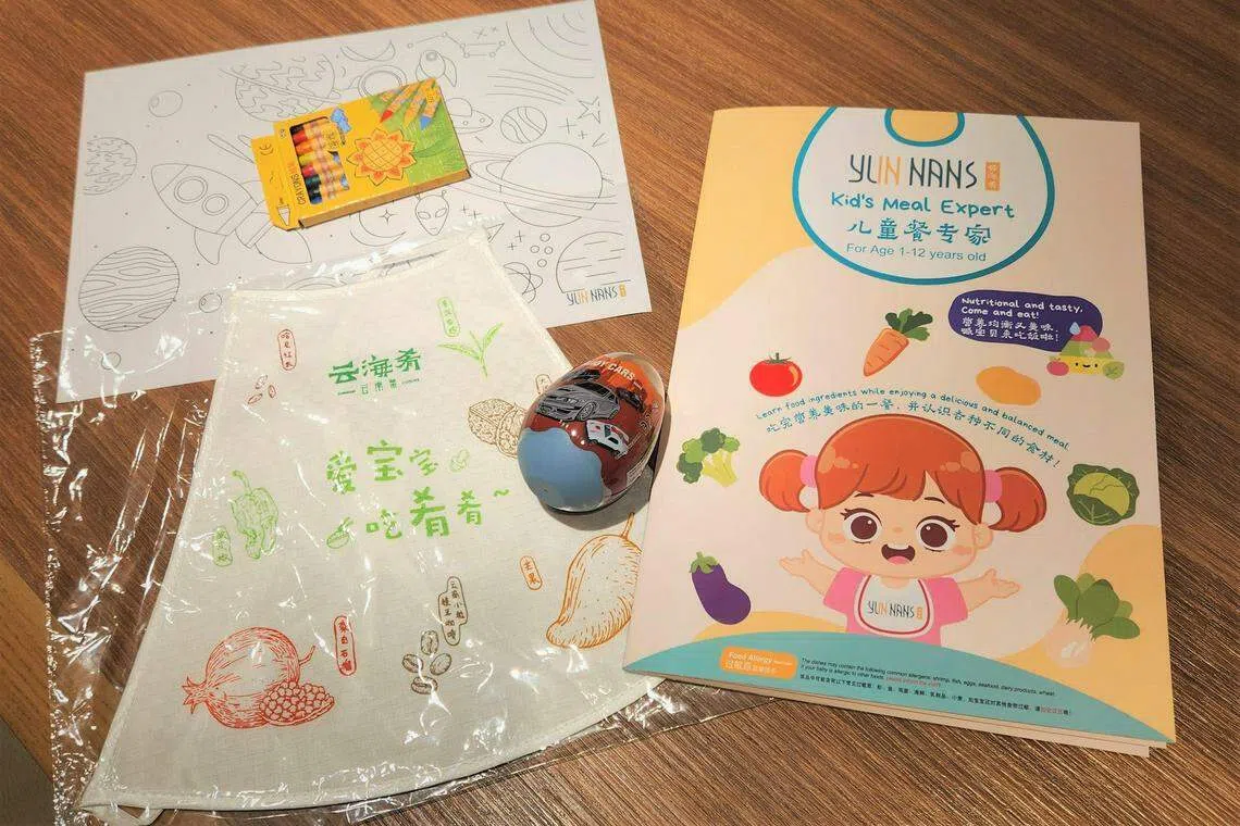 专属菜单（右）、填色纸和彩色笔、围兜和小玩具，提供小朋友完美用餐体验。（陈爱薇摄）