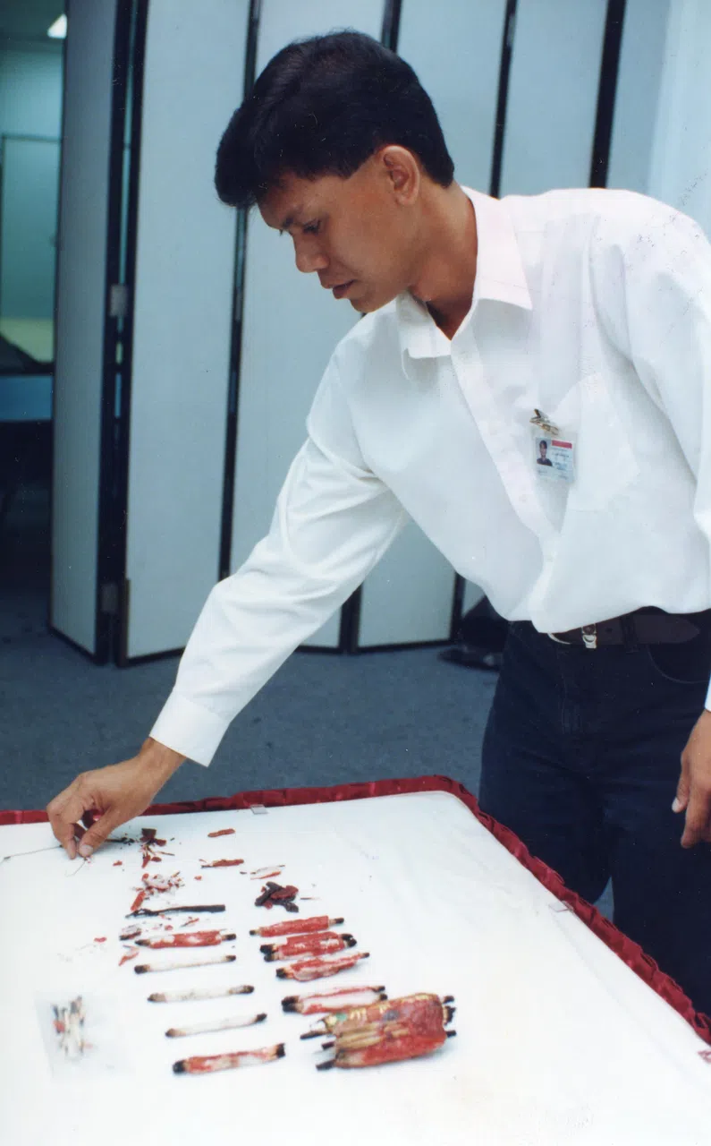 1998年9月，烧车狂在牛车水客纳街准备下手时被捕，当年领导“火轮”专案小组的陈炳坤警长，在记者会上展示干案工具。（档案照片）