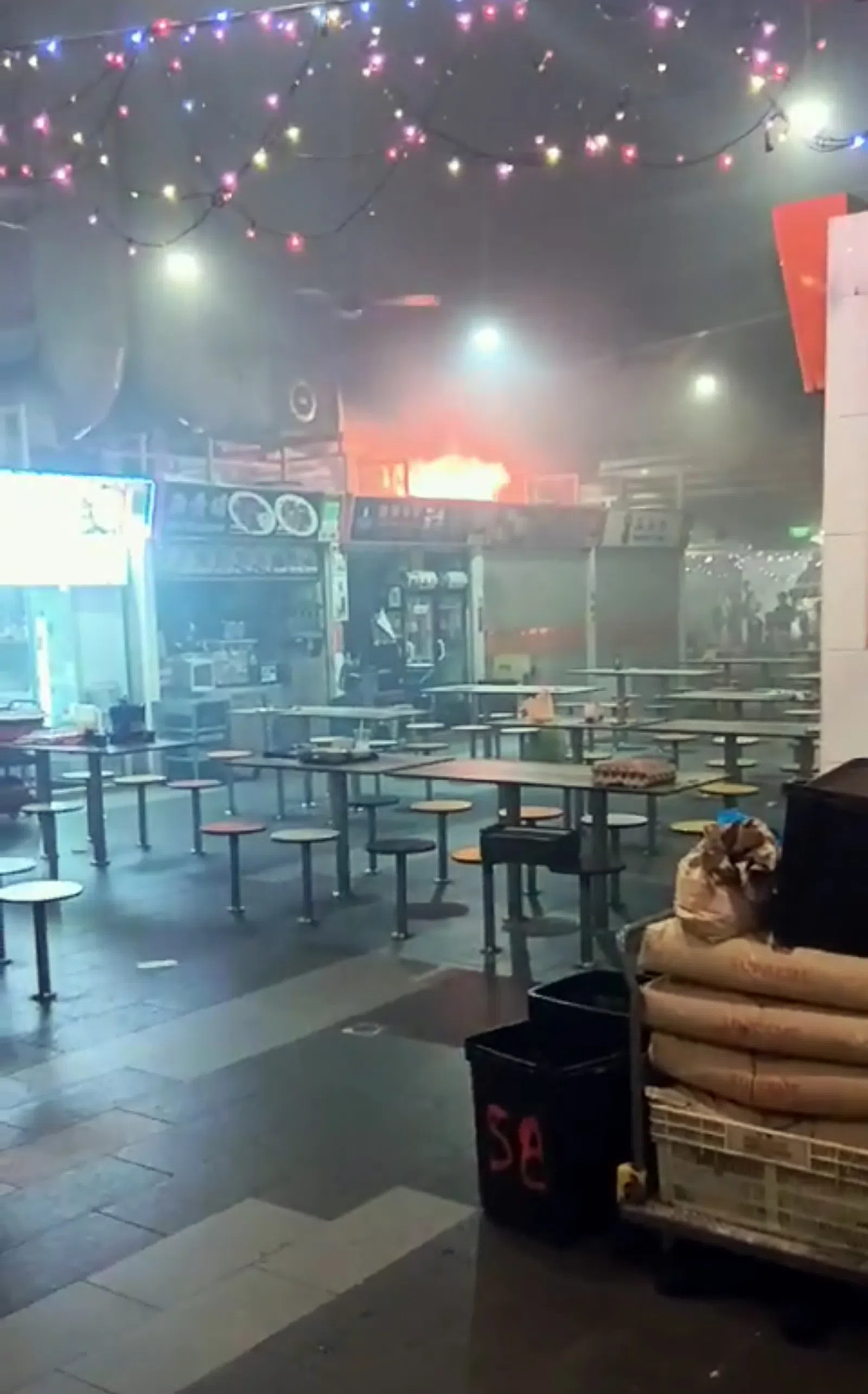 摊位失火狂烧，浓烟弥漫。（受访者提供）