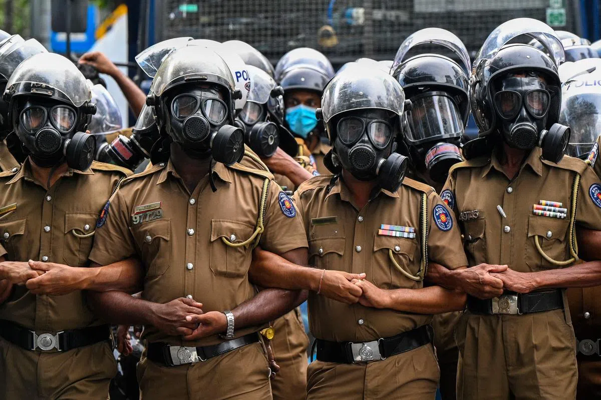 斯里兰卡政局动荡多时，在7月的骚乱后，警察站成人墙围堵走上科伦坡街头示威的大学生。（法新社）