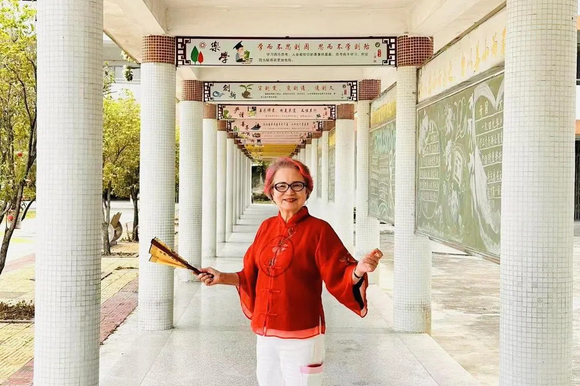 蓉子喜欢顶着一头红彤彤的头发，别人投以异样眼光，她坦然一笑说：“哪条法规不许啊！”她热爱生活，关爱教育与孩童。数月前，下乡到金石镇塔下小学协助学校改善校园园景。（受访者提供）
