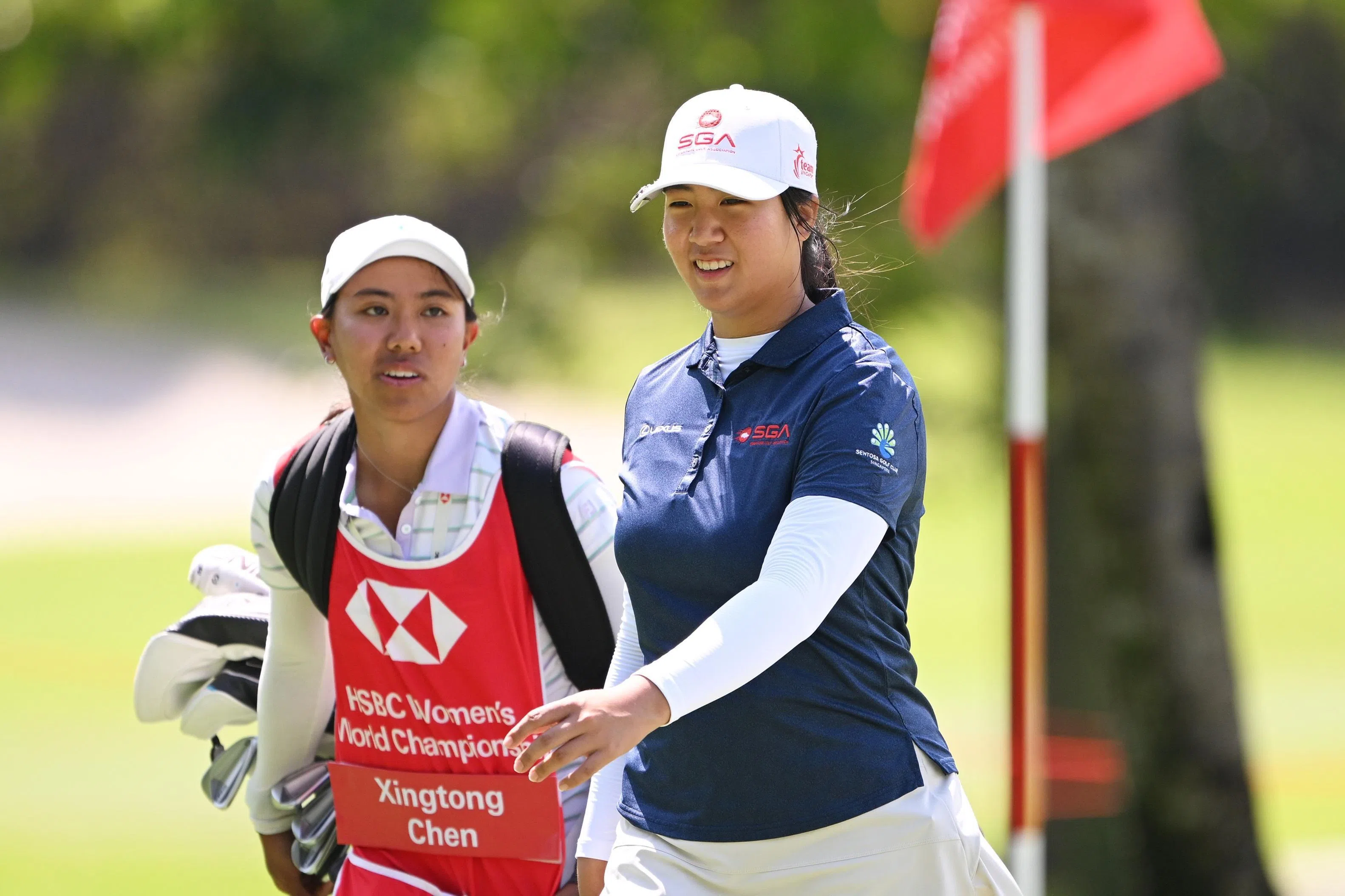 我国女将陈星彤（右）在首轮交出低于标准杆两杆的70杆，正在养伤的队友爱丽莎担任球童。（HSBC提供）