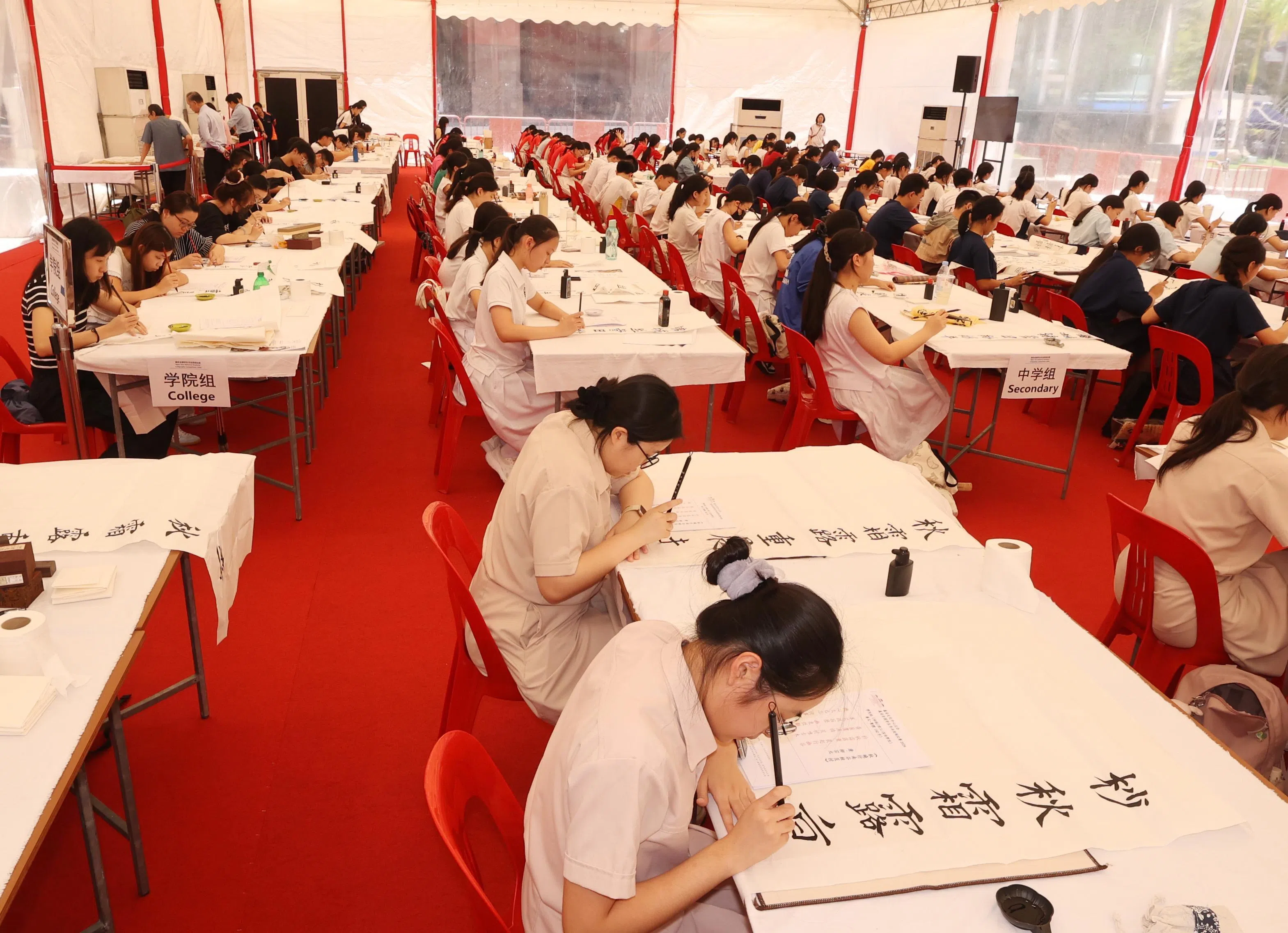 赛场上，百名学生起笔挥墨，场面盛大。（邬福梁摄）
