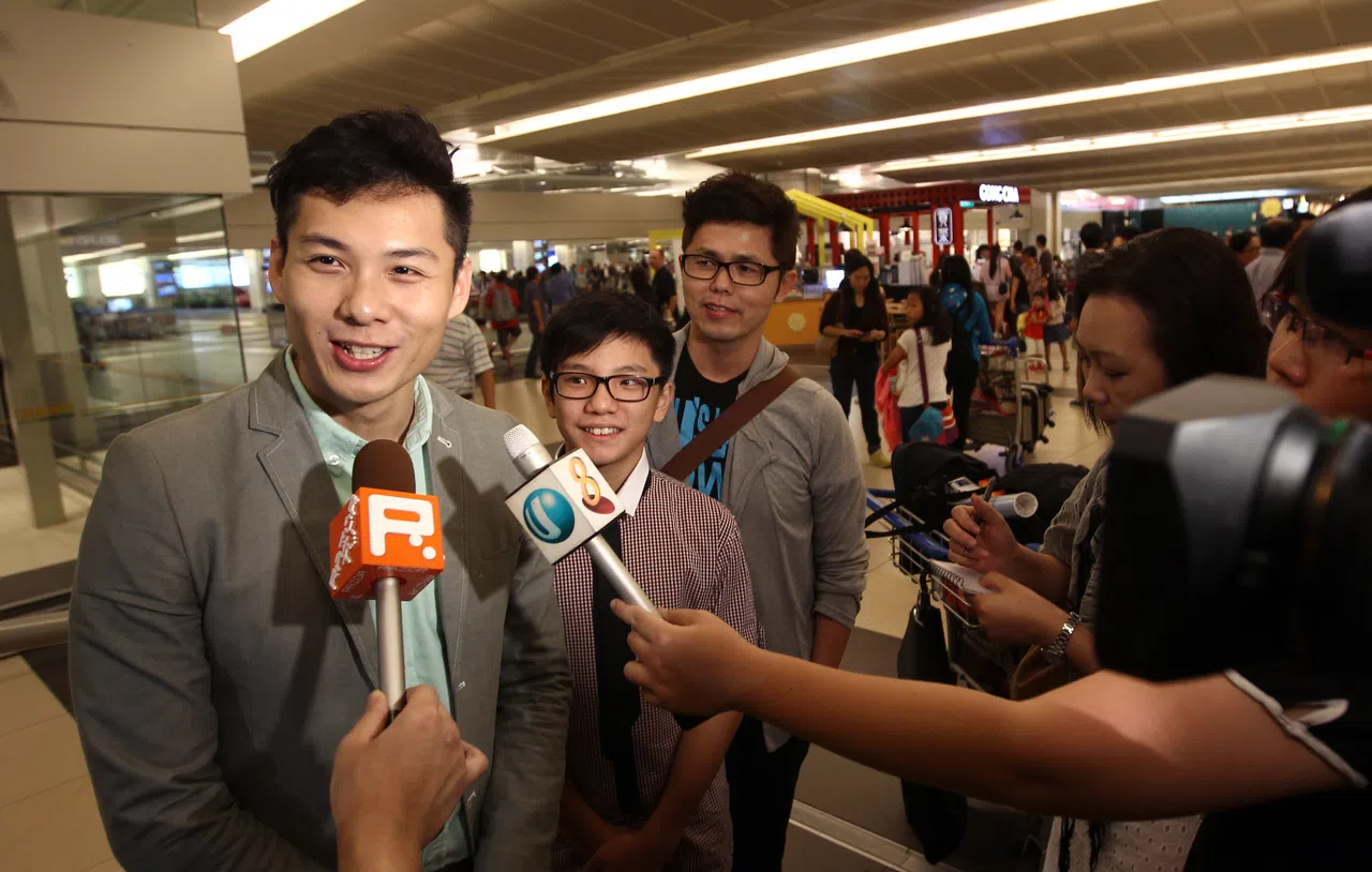 在第50届金马奖为国争光的本地导演陈哲艺（左一）与《爸妈不在家》制作人黄文鸿（左三），以及童星许家乐（左二）抵新后成为本地媒体的追访对象。（档案照）