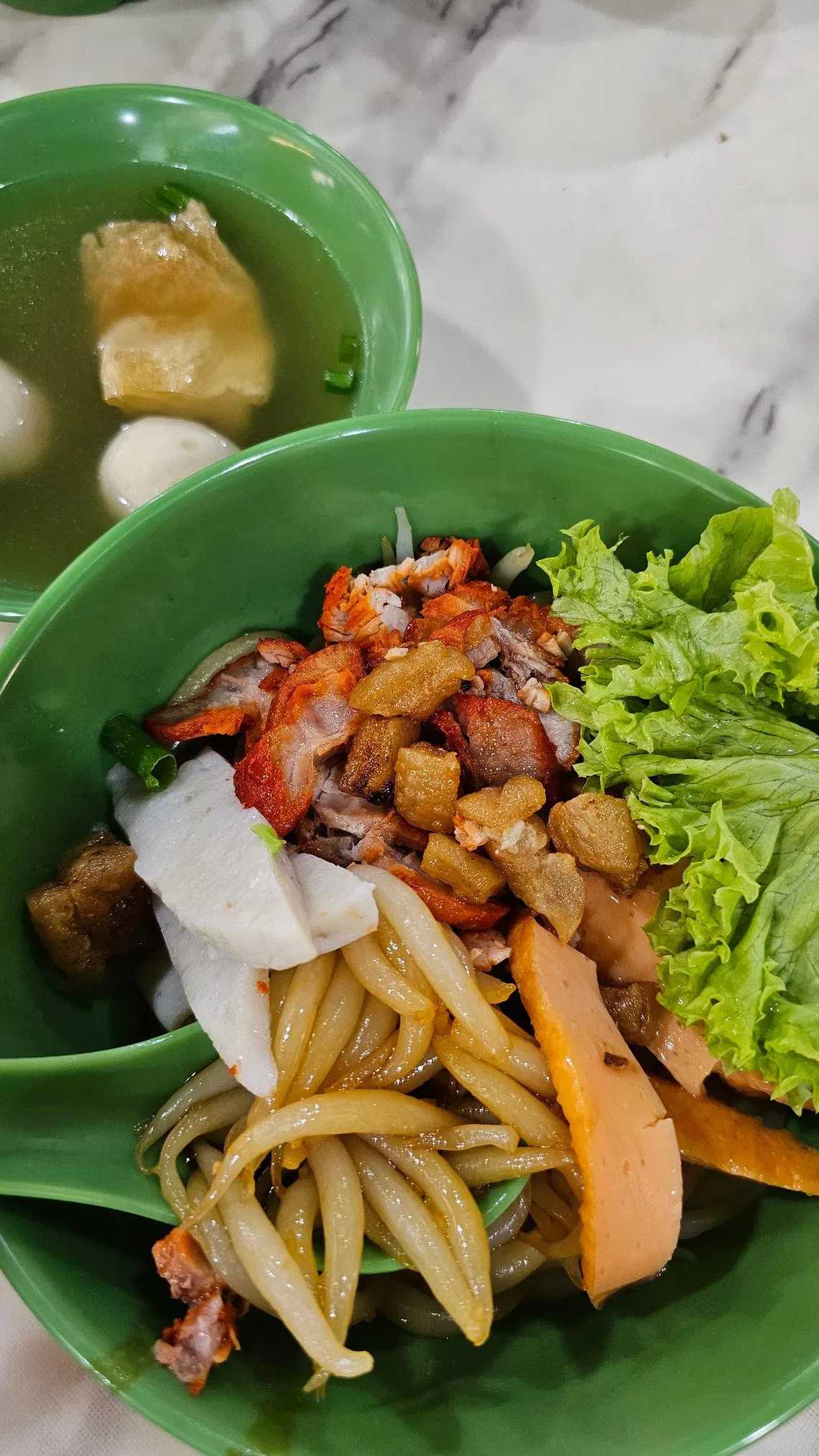 配合新加坡食客口味，“马六甲古早味”负责人调整了马六甲鱼胶面的味道，加入黑面酱。（黄亿敏摄）