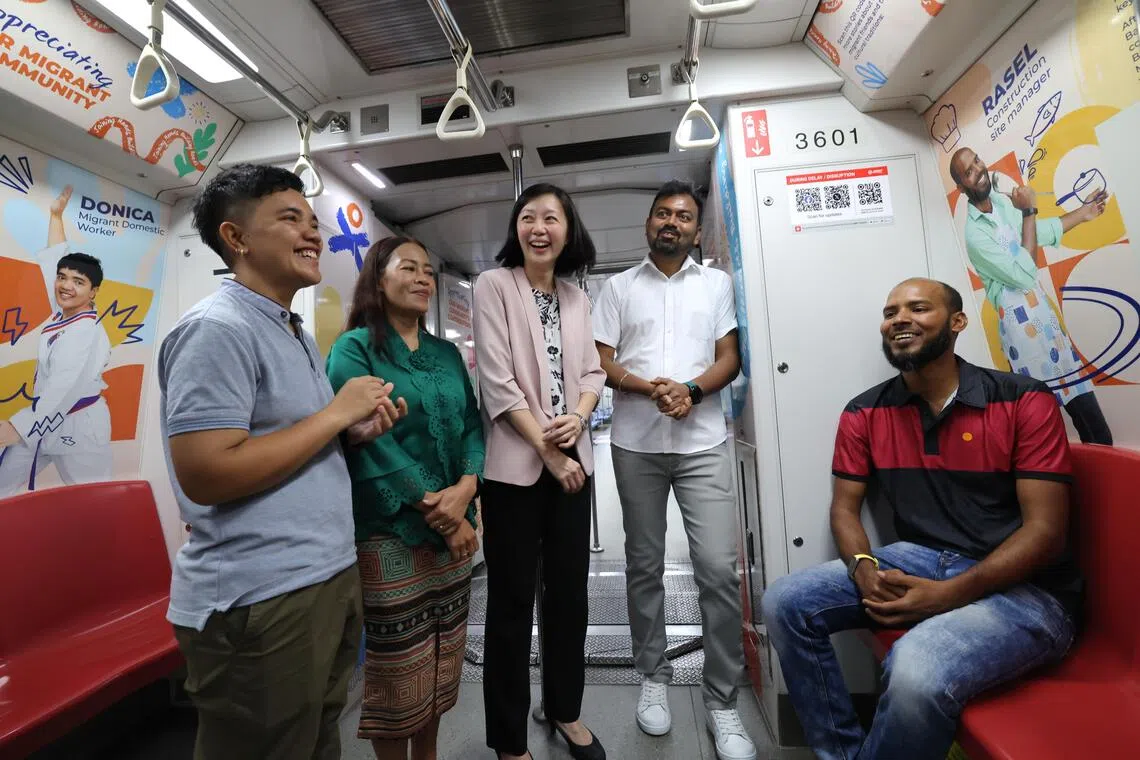 人力部副常任秘书莫捷惠（中）与四名多才多艺的客工，共同出席“国际客工日”地铁概念列车首发仪式。（梁麒麟摄）