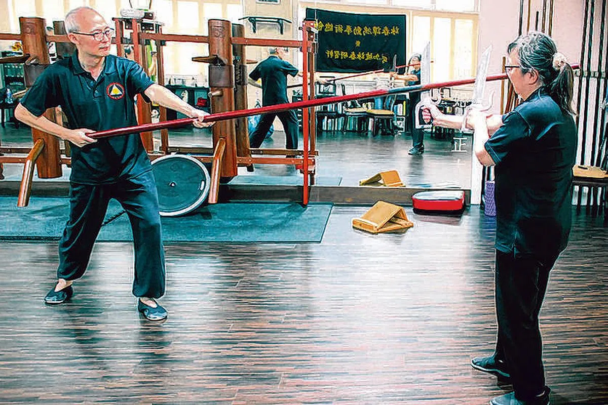 李大明和妻子示范棍法和刀法，充分反映这两种兵器的威力。