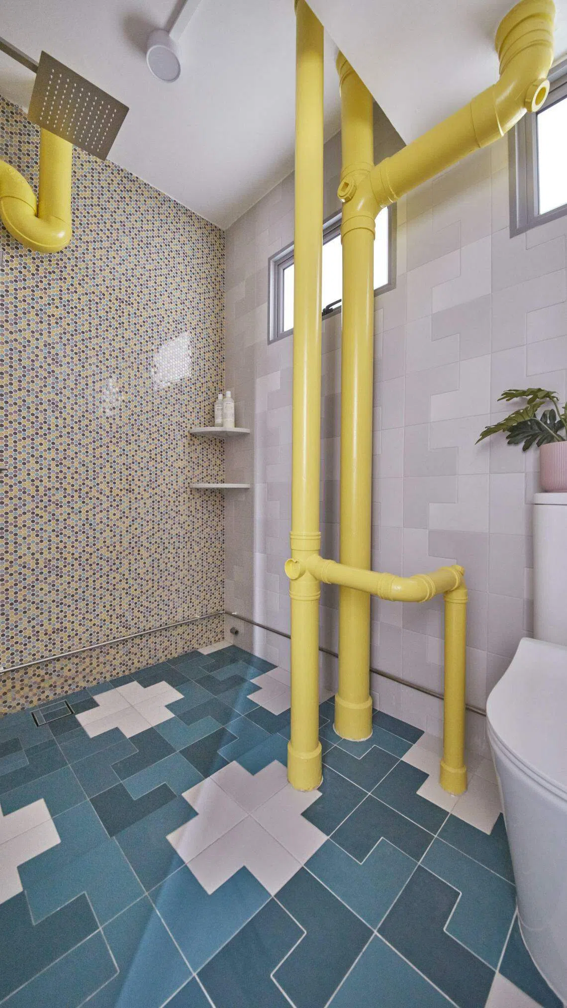 厕所不同的墙砖配搭趣味地砖，显眼的黄色水管构成设计的一部分。（Free Space Intent提供）