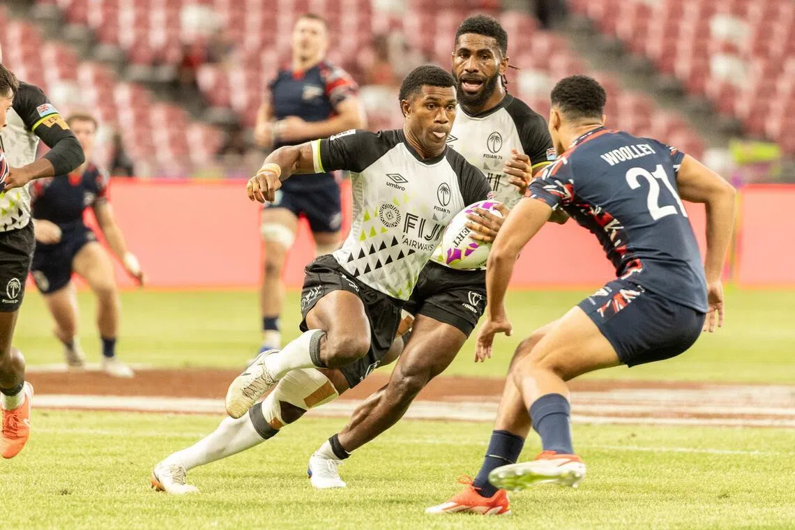 斐济男队（黑白衣）是2024年巴黎奥运亚军。本届比赛目前为止，他们发挥稳健，以一波三连胜排名小组第一出线，志在实现卫冕。（世界橄榄球联合会提供）