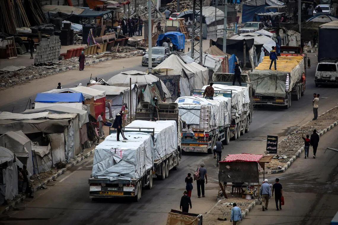 和平协议首阶段停火落实，满载救援物资的卡车终放行，星期天经埃及拉法口岸开入加沙地带难民营，为巴勒斯坦难民送上期盼已久的救命粮水。（法新社）