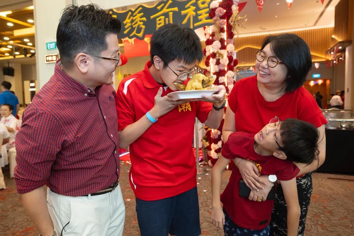 “出花园”的咬鸡头环节寓意“独占鳌头”，寄望青少年在学业与事业上勇攀高峰。（揭阳会馆提供）