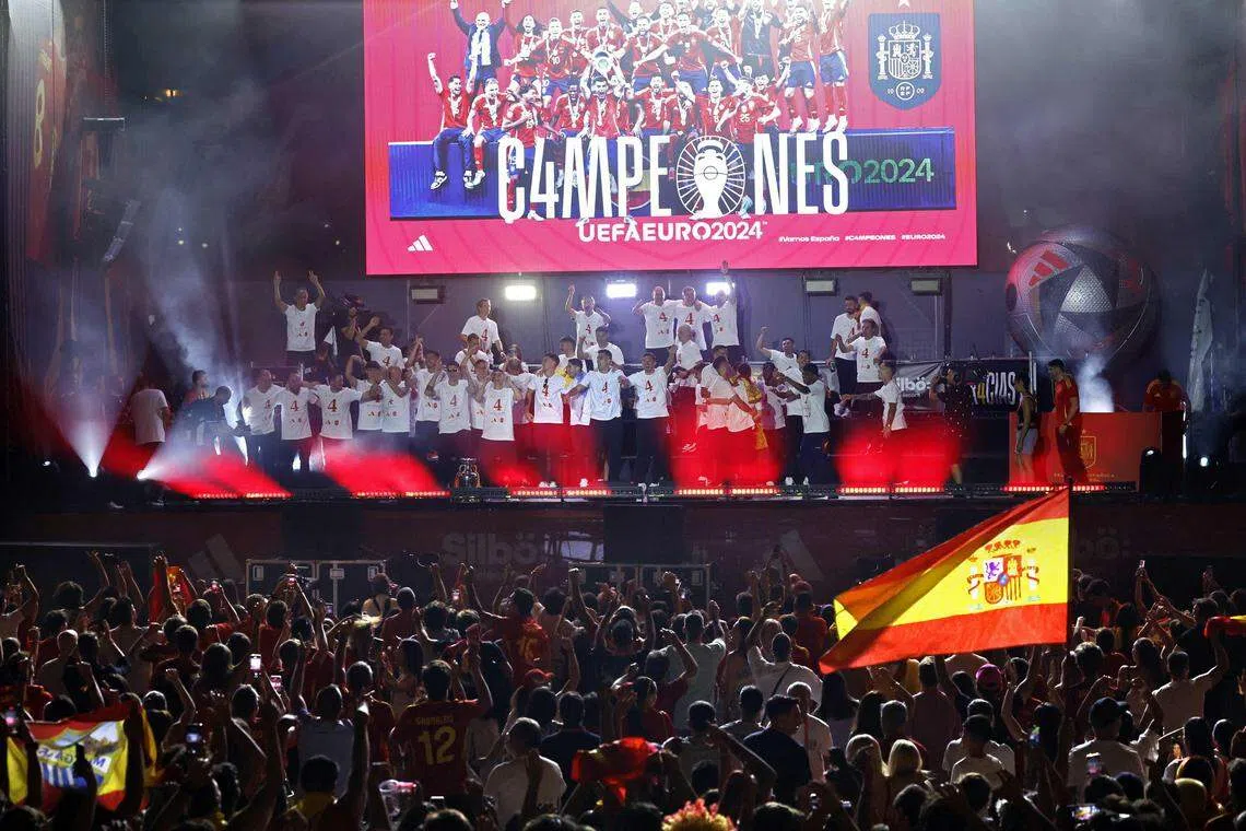 西班牙球员在台上和球迷们庆祝球队夺得欧锦赛冠军。（法新社）